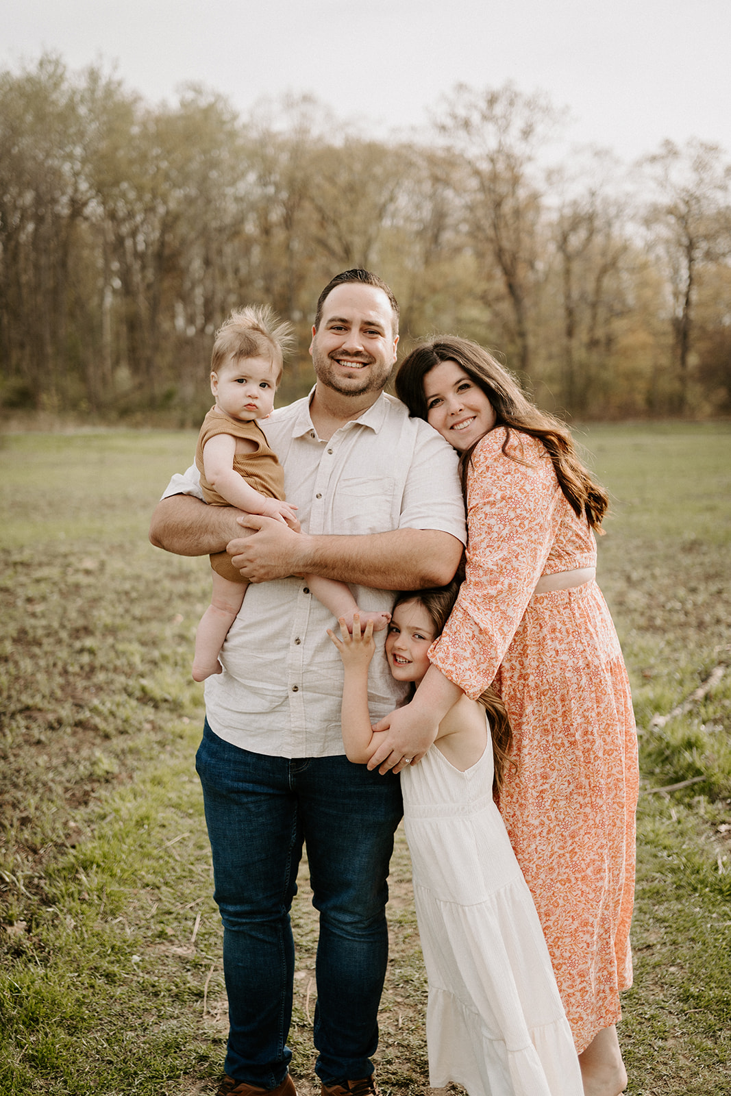 A family of four with both children around dad and mom beside dad.